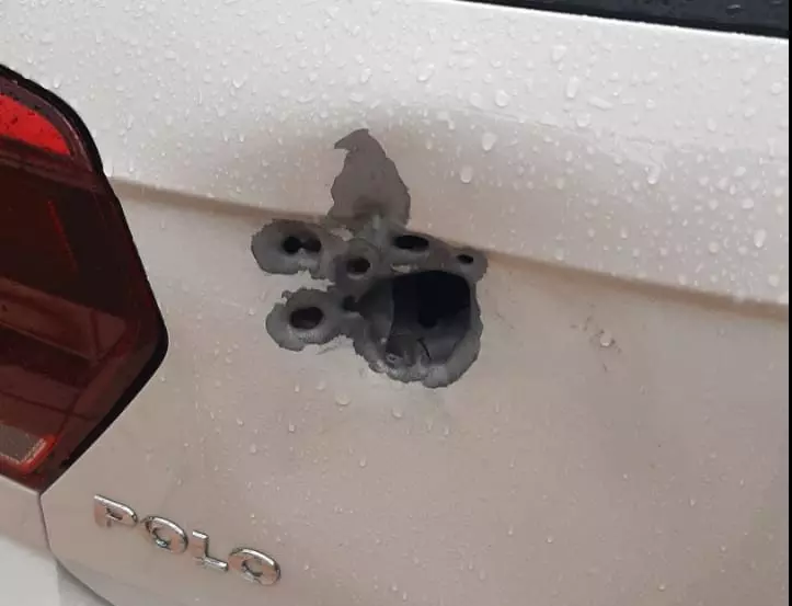 Buraco em carro mostra a dimensão do poder do armamento dos criminosos. Foto: Reprodução / Rede Social.