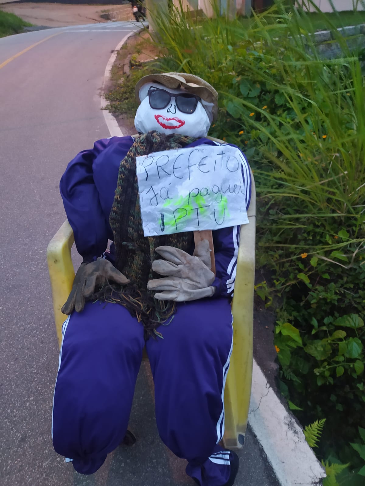 Já paguei meu IPTU morador usa boneco e cartaz para cobrar obras em rua de Laguna