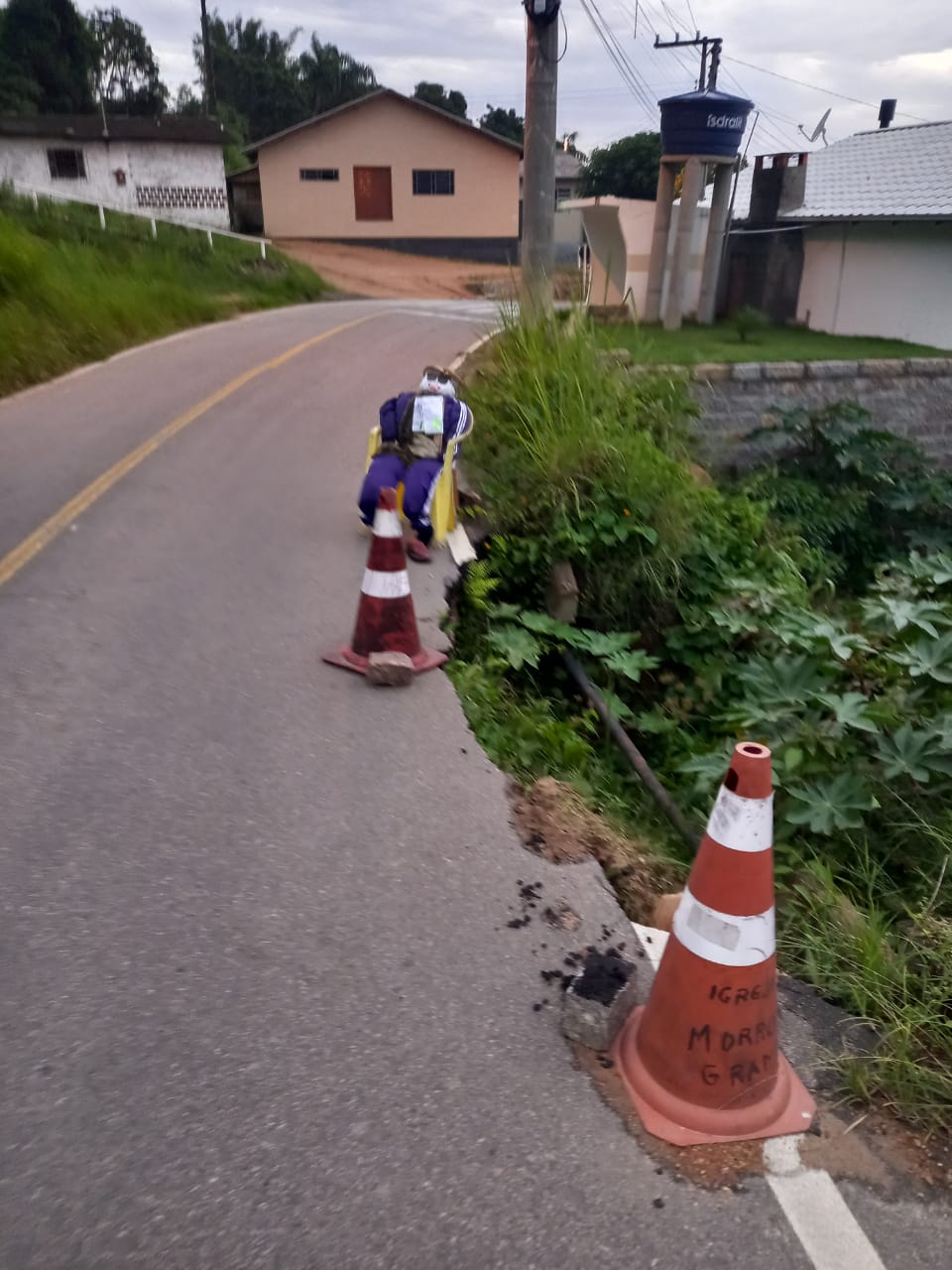 Já paguei meu IPTU morador usa boneco e cartaz para cobrar obras em rua de Laguna