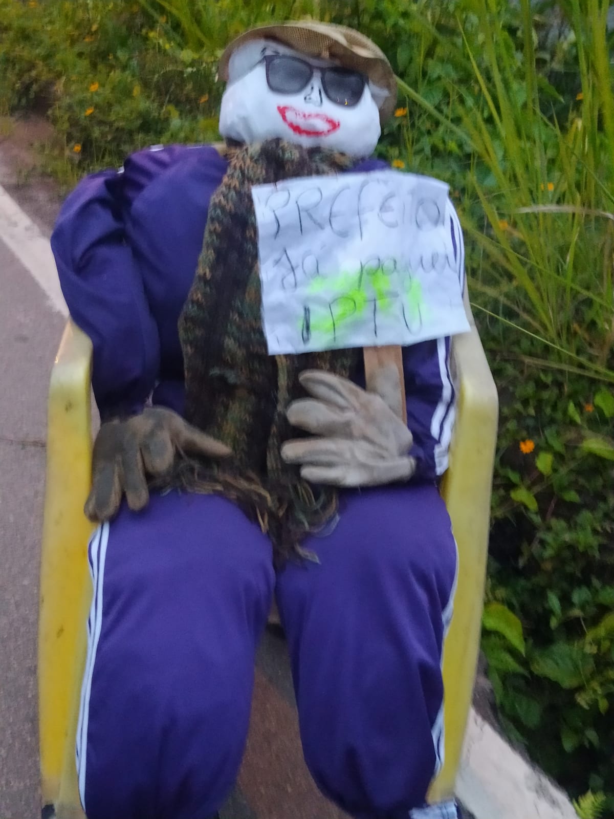 Já paguei meu IPTU morador usa boneco e cartaz para cobrar obras em rua de Laguna