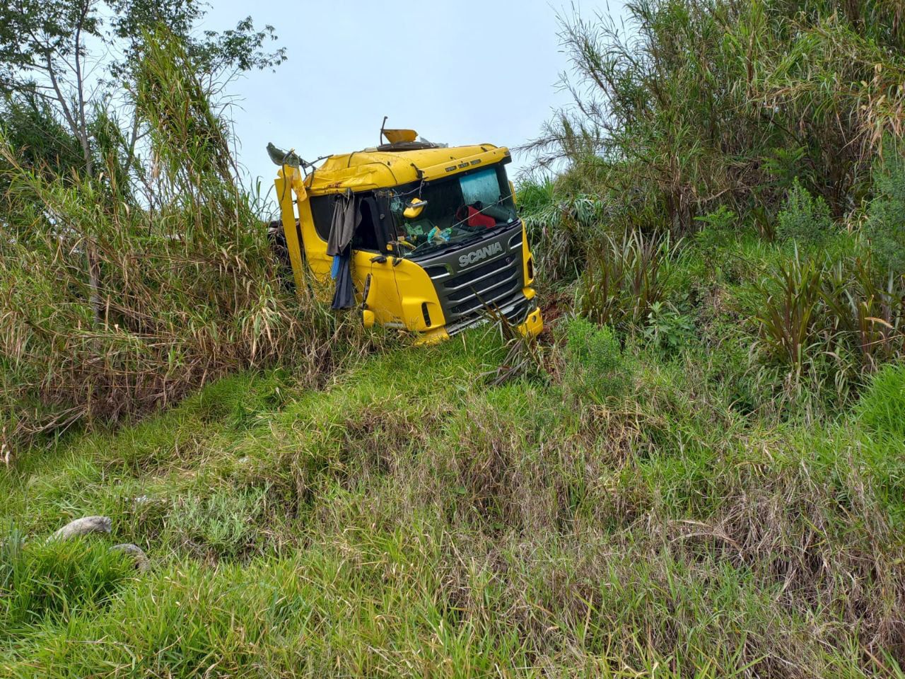 Carreta carregada com pó de pena de aves sai da pista e capota em barranco da BR-282