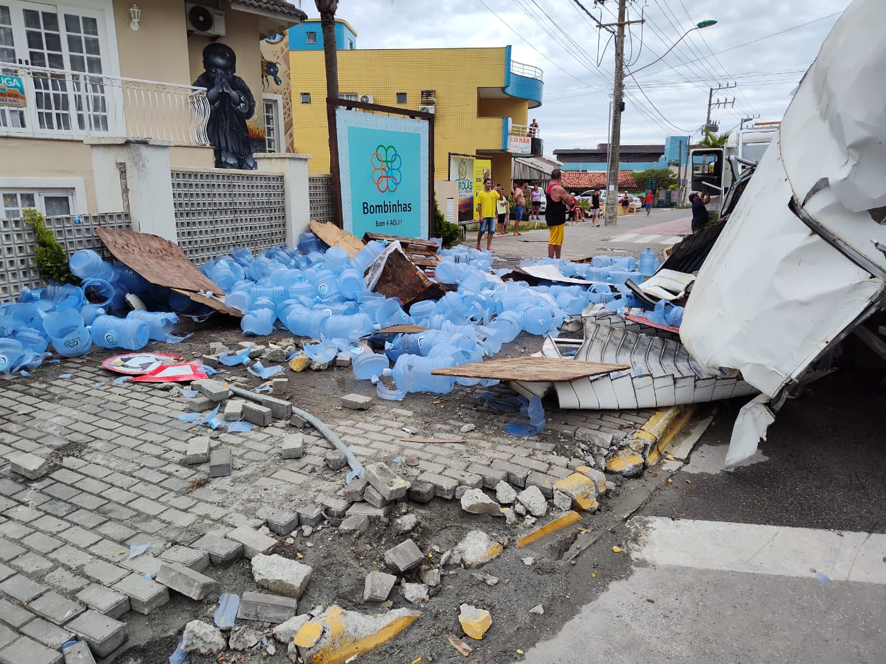 Caminhão com bombonas de água tomba