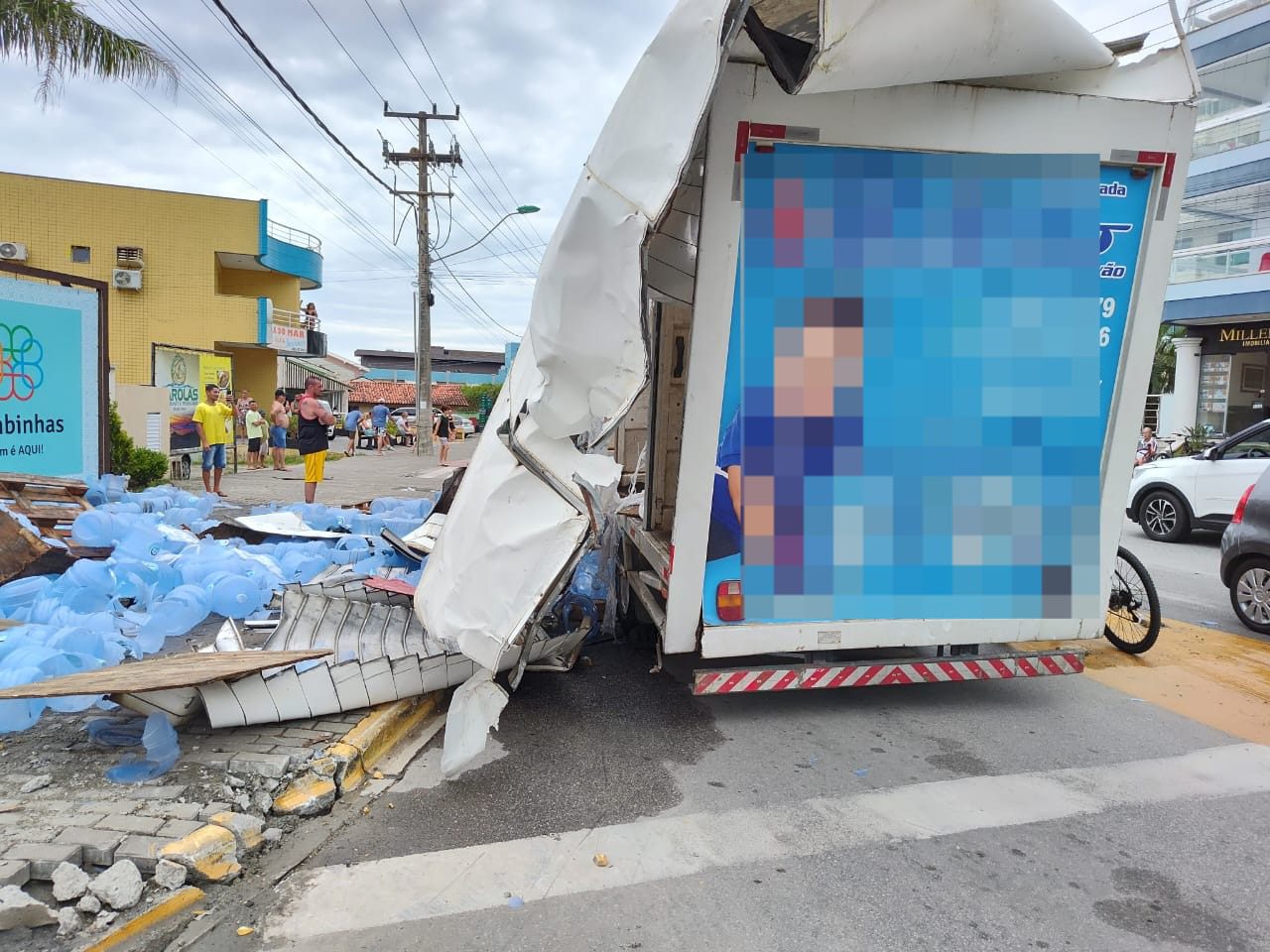 Caminhão com bombonas de água tomba