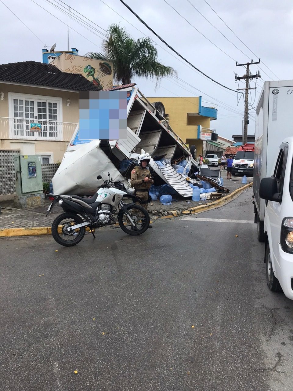 Caminhão com bombonas de água tomba