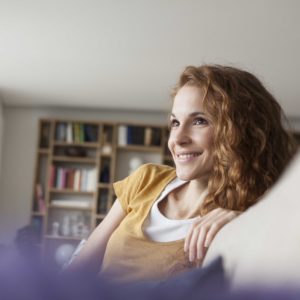 Smiling woman at home sitting on couch