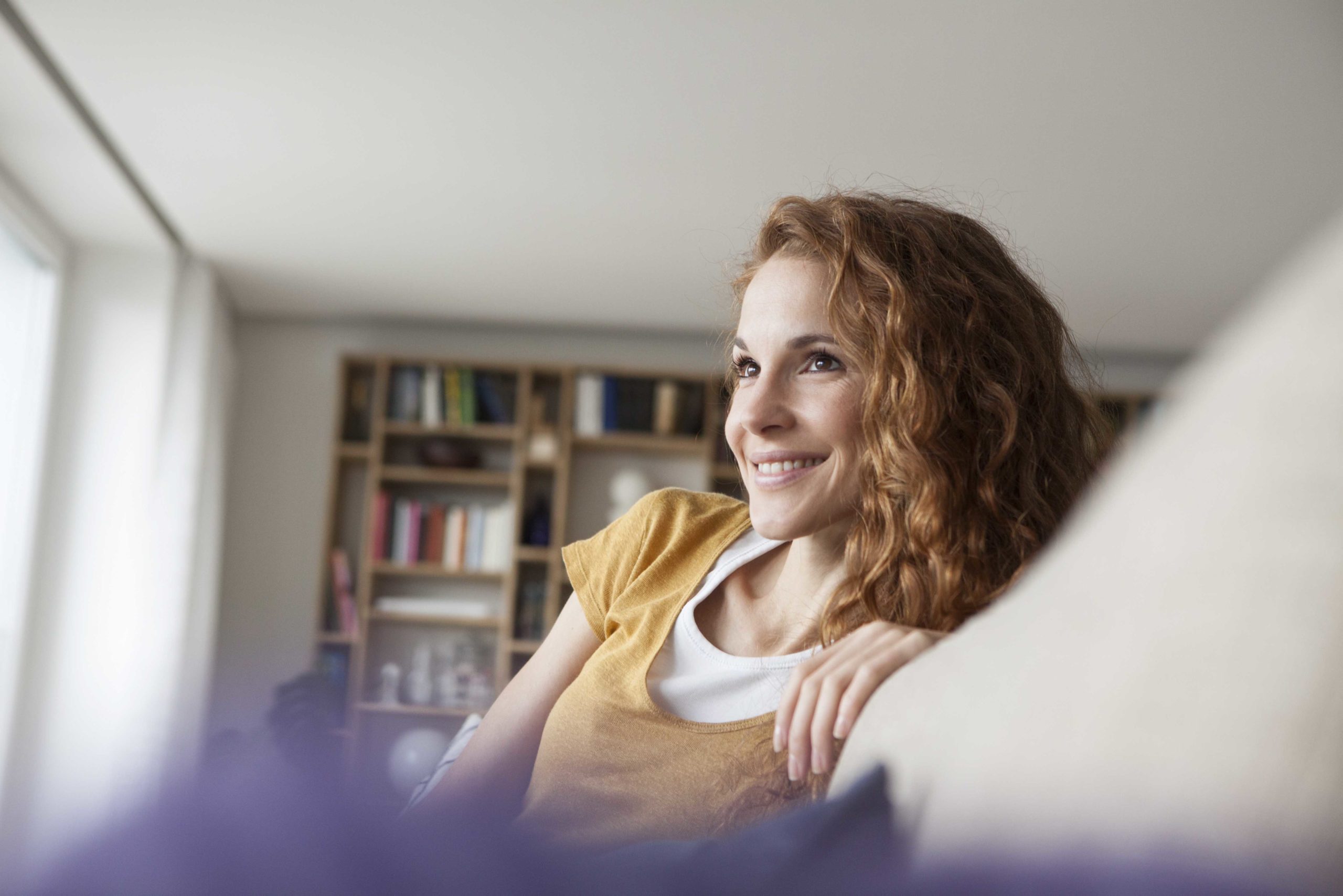 Smiling woman at home sitting on couch