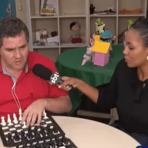 Marcos Antônio Schllosser, enxadrista deficiente visual, está ao lado da repórter, mostrando como joga Xadrez | Foto: SCC SBT 