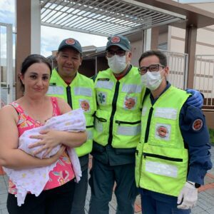 Vizinha da criança segura bebê com equipe do Corpo de Bombeiros (Foto: CBMSC)