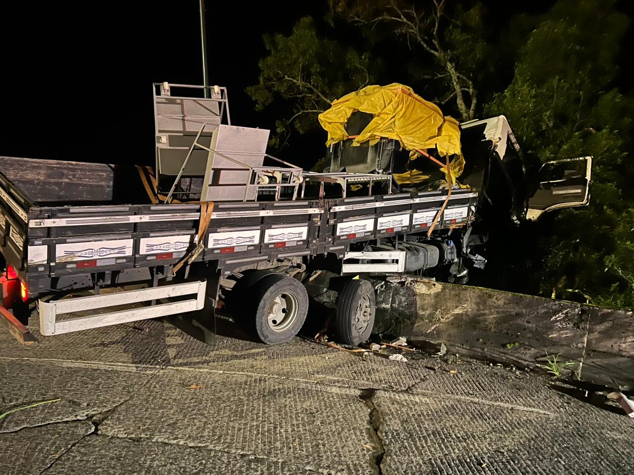 O caminhão ficou com a parte da frente pendurada na mureta | Foto: PMRV