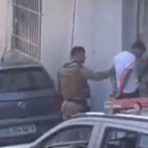 Vídeo flagra policial colocando objeto na cintura de homem algemado durante prisão em SC | Imagem: Reprodução/Redes Sociais 
